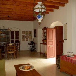 Spacious living area of Sior Nikoletos with traditional Cretan stone walls and vintage-style furniture