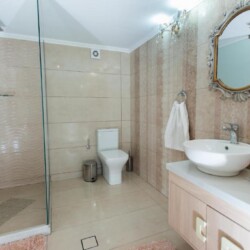 Modern bathroom with glass shower enclosure, sleek fixtures, and neutral tones at Villa Virginia in Kalamaki.