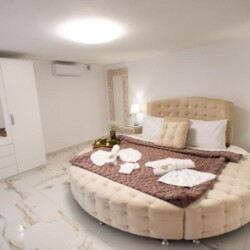 Luxurious bedroom with a round velvet bed and ambient lighting at Villa Virginia in Kalamaki, Crete.