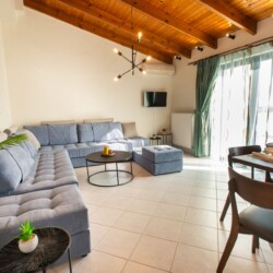 Spacious living area with sea view and large couch in Suite Thea
